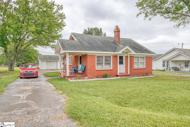 view of front of home featuring a garage, covered porch, and a front yard