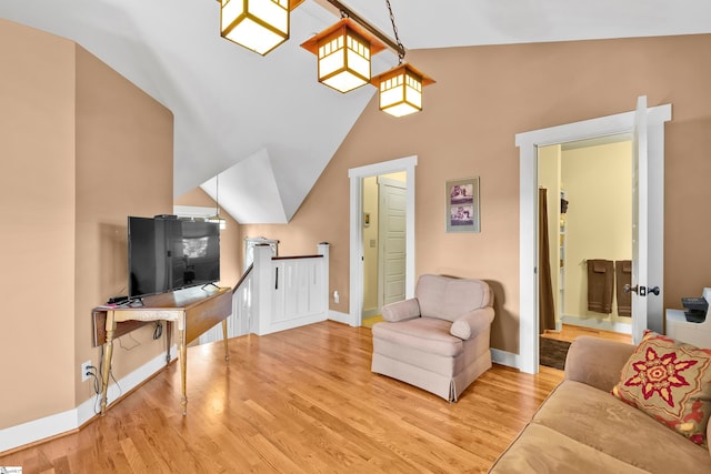 living room featuring lofted ceiling and light hardwood / wood-style floors