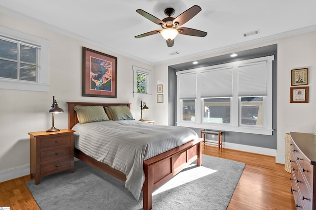 bedroom featuring crown molding, ceiling fan, and light hardwood / wood-style flooring