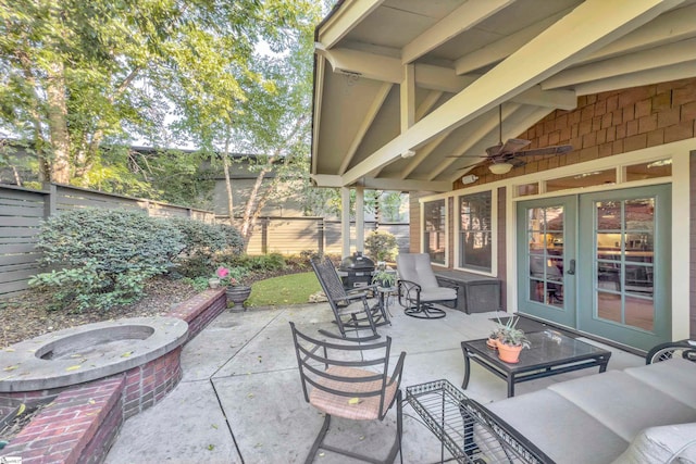 view of patio / terrace featuring an outdoor living space with a fire pit, ceiling fan, and french doors