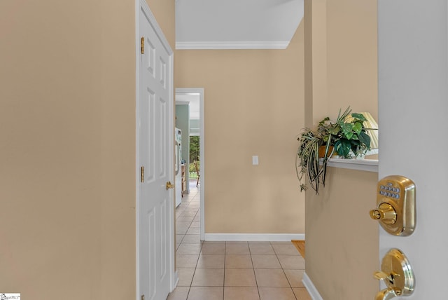 hall with baseboards, ornamental molding, and light tile patterned flooring