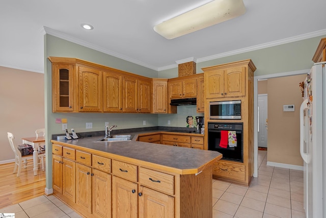 kitchen with light tile patterned flooring, a sink, under cabinet range hood, ornamental molding, and black appliances