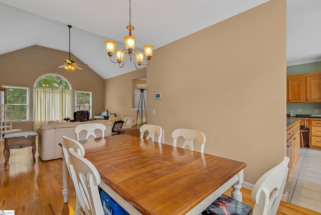 dining space featuring vaulted ceiling, ceiling fan with notable chandelier, and light wood-style flooring