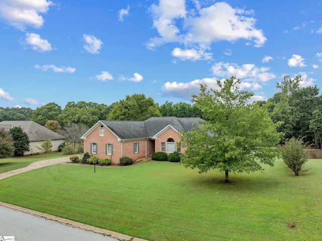 ranch-style house with concrete driveway, brick siding, and a front yard