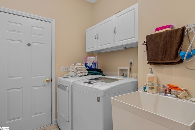 washroom with cabinet space, a sink, and washer and dryer