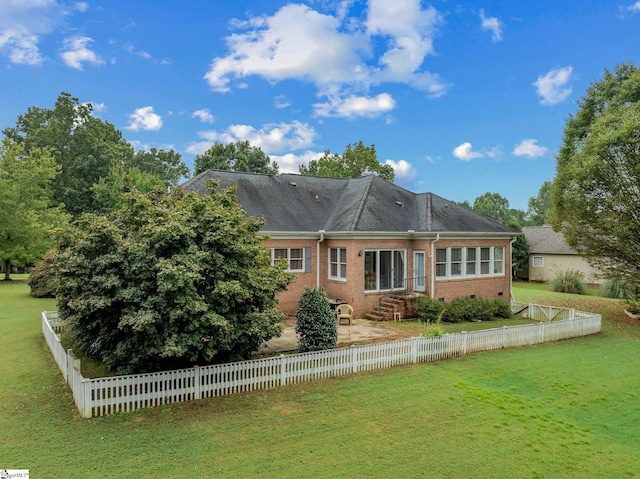 back of property featuring fence, a patio, brick siding, entry steps, and a lawn