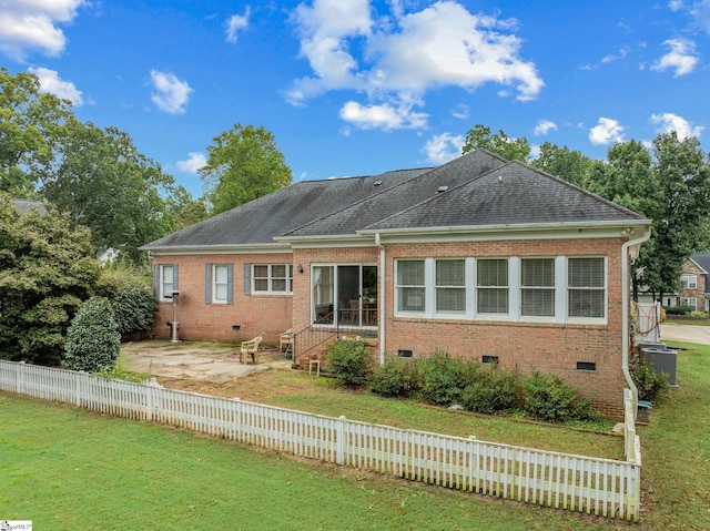 rear view of house with crawl space, fence private yard, brick siding, a yard, and a patio