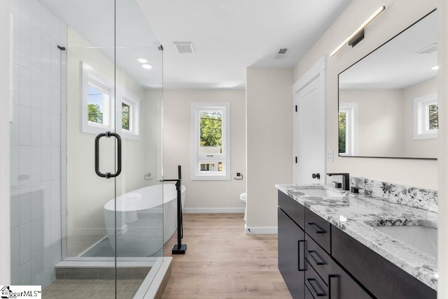 full bathroom featuring wood-type flooring, vanity, toilet, and separate shower and tub