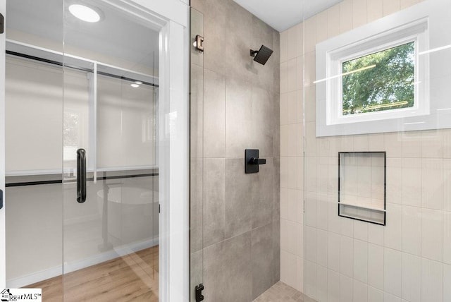 bathroom with hardwood / wood-style floors and an enclosed shower