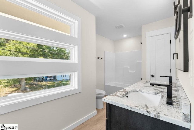 bathroom featuring wood-type flooring, a shower, vanity, and toilet