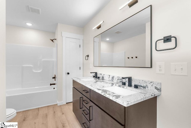 full bathroom featuring shower / tub combination, vanity, toilet, and hardwood / wood-style flooring