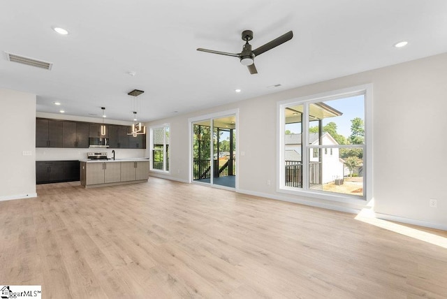 unfurnished living room with light wood-type flooring and ceiling fan