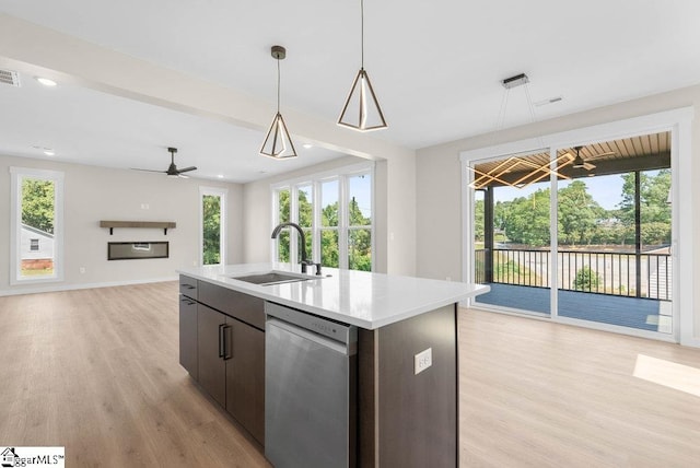 kitchen with a wealth of natural light, dishwasher, a kitchen island with sink, and sink