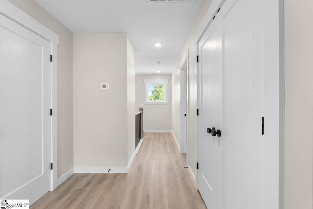 hallway with light hardwood / wood-style floors