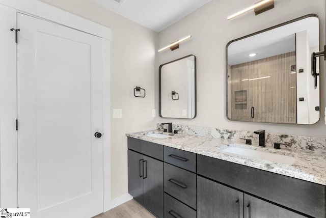 bathroom featuring walk in shower, vanity, and hardwood / wood-style floors