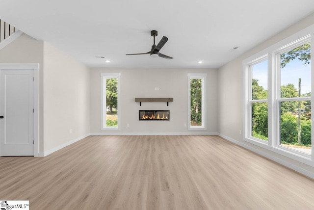 unfurnished living room with ceiling fan, light hardwood / wood-style flooring, and plenty of natural light