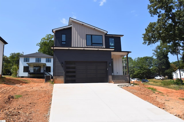 contemporary house featuring central AC, concrete driveway, board and batten siding, and an attached garage