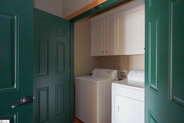 laundry area with washer and clothes dryer and cabinets