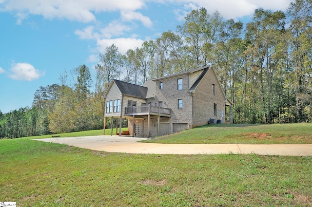 rear view of house with a wooden deck and a lawn