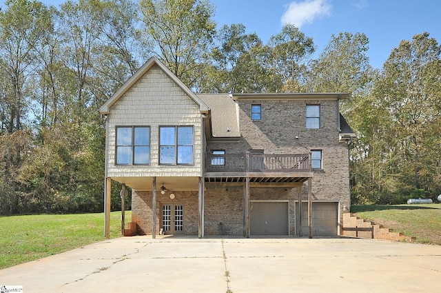 back of house with a lawn, a wooden deck, and a garage