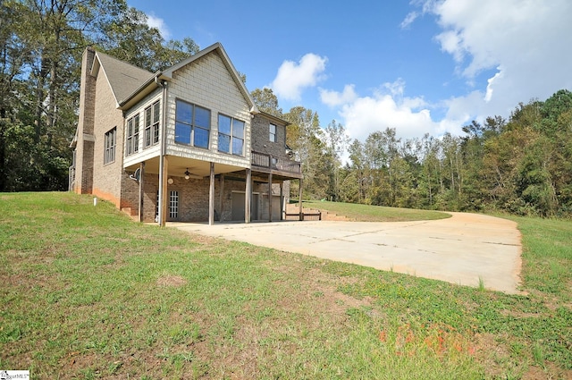 exterior space with ceiling fan, a yard, and a carport