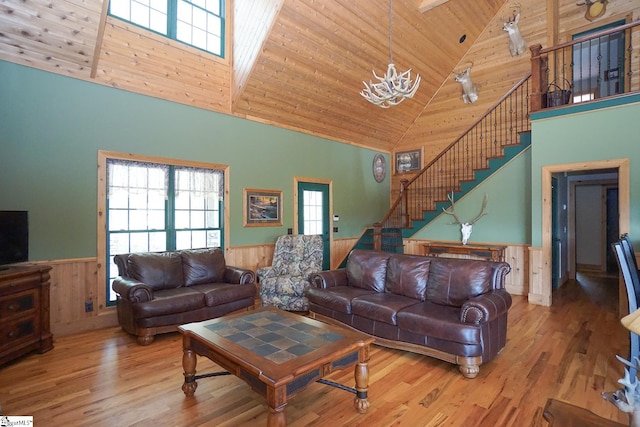 living room with wood ceiling, wooden walls, hardwood / wood-style floors, and high vaulted ceiling