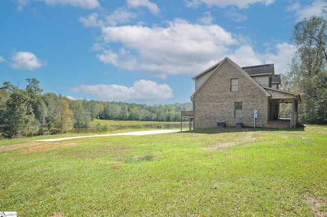 view of side of home featuring central AC unit and a lawn