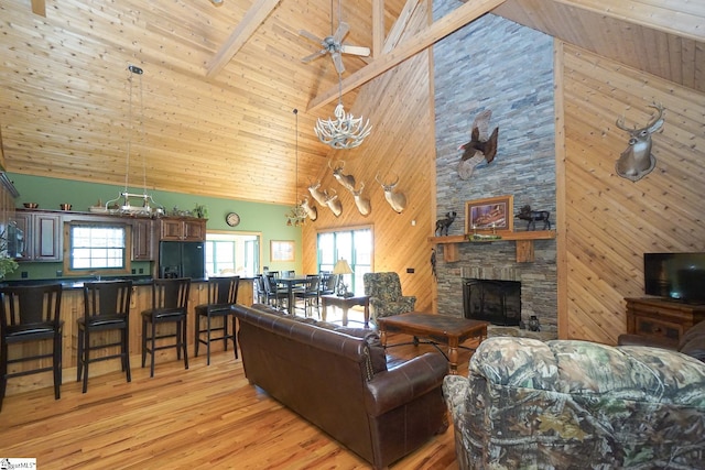 living room with high vaulted ceiling, beam ceiling, plenty of natural light, and a fireplace