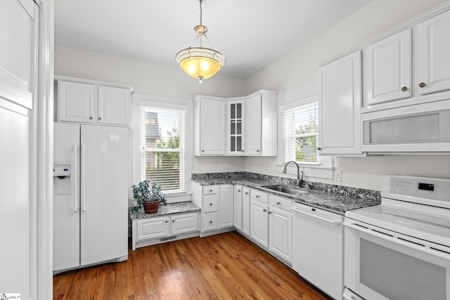 kitchen with white appliances, sink, white cabinets, and a wealth of natural light