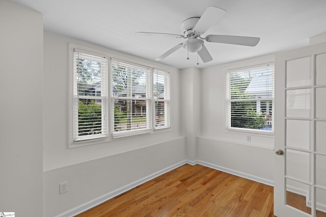 spare room featuring ceiling fan, hardwood / wood-style flooring, and plenty of natural light