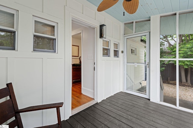 unfurnished sunroom featuring wood ceiling, ceiling fan, and plenty of natural light