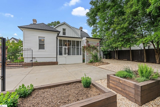 back of house featuring a sunroom and a patio