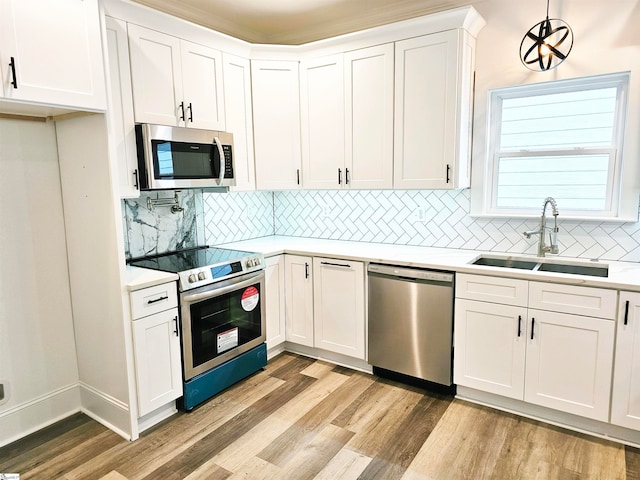 kitchen with appliances with stainless steel finishes, sink, and white cabinets