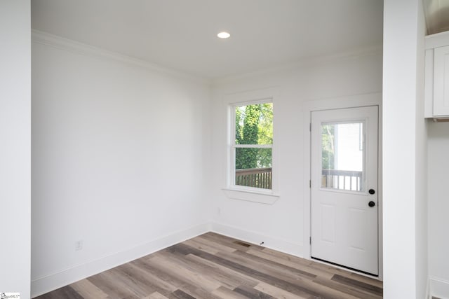 doorway with crown molding and hardwood / wood-style floors