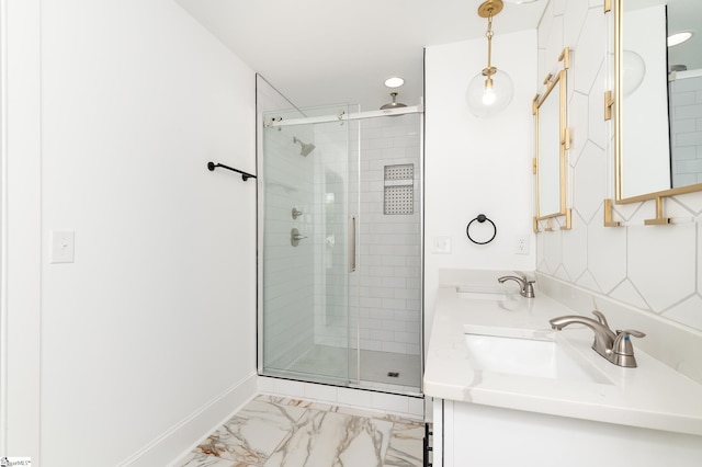 bathroom featuring a shower with door and vanity