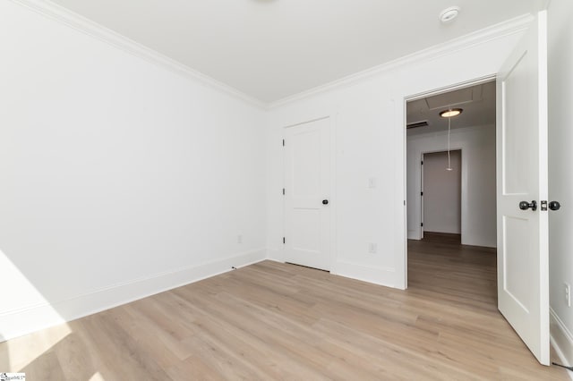 spare room with ornamental molding and light hardwood / wood-style floors