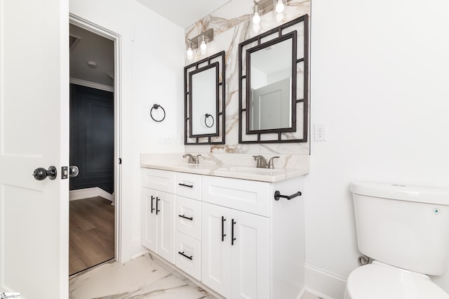 bathroom featuring ornamental molding, vanity, and toilet