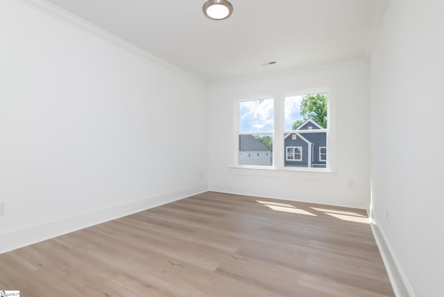 unfurnished room with light wood-type flooring and crown molding