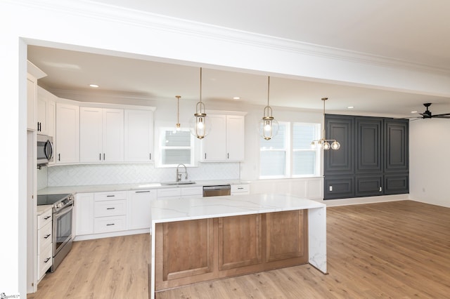 kitchen featuring white cabinets, appliances with stainless steel finishes, light hardwood / wood-style floors, and a center island