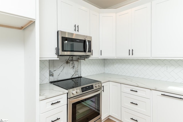 kitchen with light stone counters, appliances with stainless steel finishes, decorative backsplash, and white cabinetry