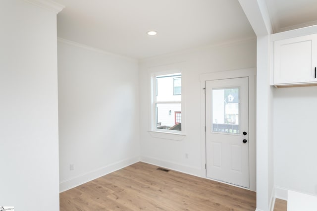 entryway featuring ornamental molding and light hardwood / wood-style flooring