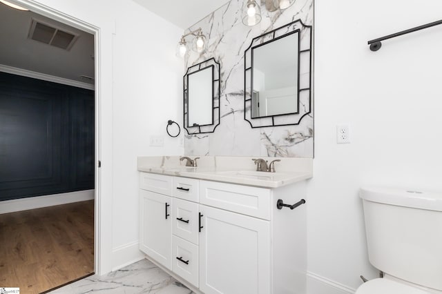 bathroom featuring vanity, crown molding, and toilet