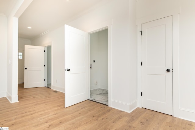 interior space featuring crown molding and light hardwood / wood-style flooring