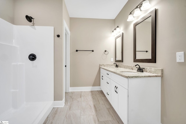 bathroom featuring a shower and vanity