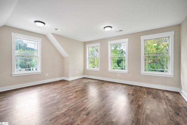 additional living space with vaulted ceiling and dark wood-type flooring