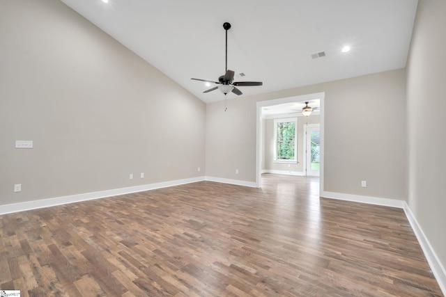 empty room featuring vaulted ceiling, dark hardwood / wood-style floors, and ceiling fan