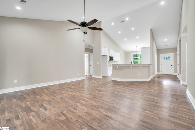 unfurnished living room with high vaulted ceiling, ceiling fan, and dark hardwood / wood-style floors