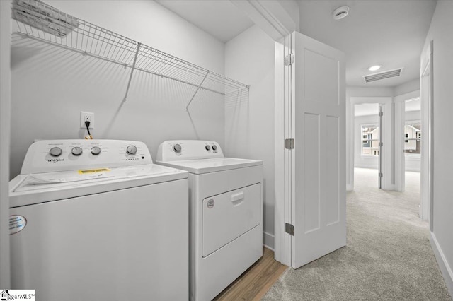 washroom featuring light colored carpet and washing machine and clothes dryer