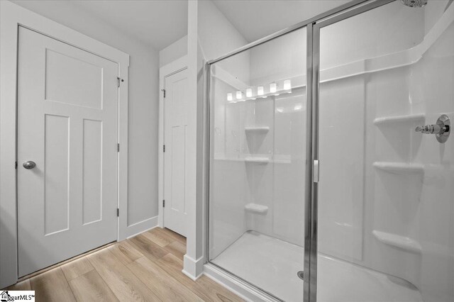 bathroom with wood-type flooring and walk in shower