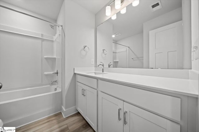 bathroom with  shower combination, vanity, and hardwood / wood-style floors